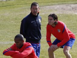 Simeone observa los ejercicios que realizan Paulo Assunçao (izq.) y Filipe Luis durante el entrenamiento. EFE  /