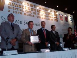 Autoridades del Hospital Civil de Guadalajara entregan reconocimiento al ponente, tras su conferencia sobre la inseguridad alimentaria.  /