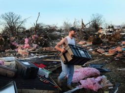 Josh Summers busca sus posesiones entre los escombros luego de que un tornado destrozó parte de su vecindario. AFP  /