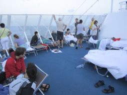 Pasajeros descansan en la cubierta del Costa Allegra, a la deriva en el Océano Índico.  REUTERS  /
