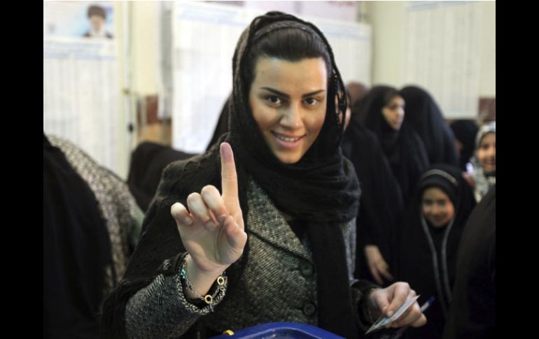 Una mujer iraní muestra su dedo marcado con tinta tras haber votado en las elecciones legislativas celebradas hoy. EFE.  /