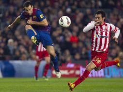 Mascherano trata de mandar un pase sobre la marca de un jugador del Sporting de Gijón. EFE  /