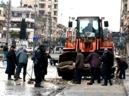 Una de las pocas fotografías tras el inicio de la revuelta en Siria. Autoridades del régimen limpian escombros en Homs. EFE  /