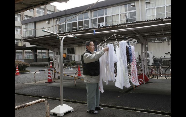 Un daminificado cualga su ropa a secar en un refugio de Fukushima. AP  /