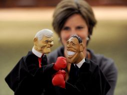 Una mujer sostiene una marioneta de Gingrich (izq) y de Obama (der). EFE  /