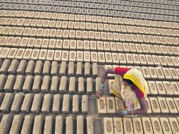 Una mujer trabaja en una fábrica de ladrillos y construcción en Jamu (India), un empleo poco común para mujeres. AP  /