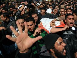 Familiares de los palestinos muertos en ataques aéreos israelíes, durante un funeral masivo en la mezquita Al-Omari. AFP  /