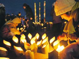 Familiares de las víctimas del tsunami de Japón prenden velas en su honor. AP  /