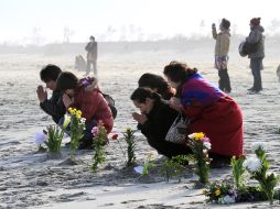 En las ciudades y pueblos devastados, los familiares de los 19 mil muertos  y desaparecidos se recogieron para orar. EFE  /