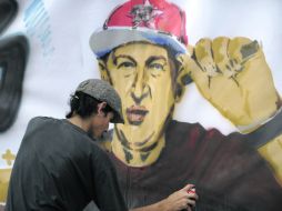 Un hombre da los últimos toques a un dibujo de Chávez, durante un acto en que seguidores le desearon pronta recuperación. AFP  /