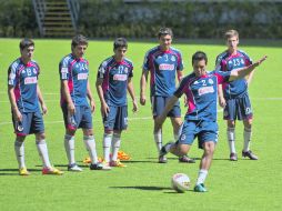 El defensor Mario de Luna dispara a portería durante la práctica en el Omnilife, ante la mirada de Escalante (3) y de Fierro.  /