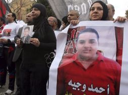 Egipcios portan carteles con las fotos de dos de las 74 víctimas de los disturbios ocurridos el pasado 1 de febrero. EFE  /