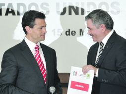 Enrique Peña Nieto entrega a Leonardo Valdés Zurita (derecha) la documentación que avala su candidatura a la Presidencia. EFE  /