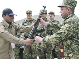 Un miembro de las Fuerzas de Seguridad Pública de Afganistán recibe un fusil en la ceremonia donde le fueron entregadas armas.EFE  /