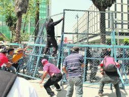 Integrantes del CNTE intentan penetrar el cerco de seguridad impuesto por la Policía. NTX  /