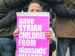 Un niño muestra una pancarta que alude a los asesinatos de menores por parte del Gobierno de Bashar al Assad. REUTERS  /