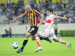 El zaguero universitario Rodrigo Follé conduce el esférico ante el agobio del futbolista de Correcaminos, Tomás Domínguez.  /