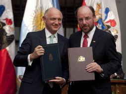 El ministro de Argentina Héctor Timetman y su contraparte de Chile Alfredo moreno muestran documentos durante una reunión. AFP  /