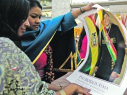 Indígenas colombianas observan un póster del presidente boliviano Evo Morales, quien visitó y permaneció en el país dos días. EFE  /