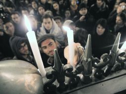 Ciudadanos encienden velas durante una marcha en París, Francia, en repudio al tiroteo. AFP  /