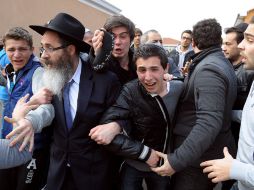Alumnos del colegio reaccionan mientras los ataúdes con los fallecidos  son sacados del colegio. AFP  /