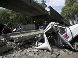Bomberos trabajan en la zona donde un puente se colapsó sobre un camión en la ciudad de  México. AFP  /