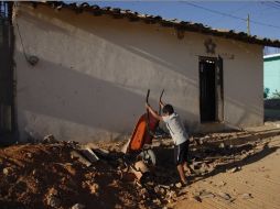 Un niño ayuda a las labores de limpieza de escombros en la localidad de San Juan Cacahuatepec. AP  /