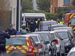 La policía y los bomberos vigilan las cercanías del edificio donde el sospechoso está acorralado. AP  /