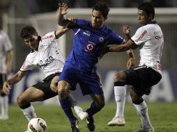 Omar Bravo es despojado del balón por los defensas Alex y Paulinho del Corinthians. AP  /