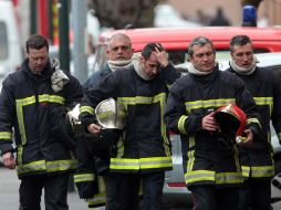 Bomberos abandonan el lugar del cerco, tras la muerte del asesino. AP  /