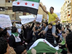 Varios Manifestantes muestran banderas pre-Baaz mientras corean consignas contra el presidente sirio, Bachar Al Asad. EFE  /