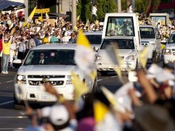 Gente saluda a Benedicto XVI en su paso por una avenida de León, Guanajuato. REUTERS  /