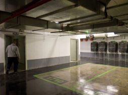 Un trabajador de mantenimiento lleva los últimos botes de agua en una sección del aparcamiento subterráneo. AP  /