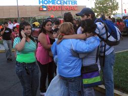 La gente se reúne frente a un supermercado después de sentirse un terremoto en Talca, Chile. AP  /