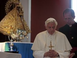 Benedicto XVI encendió un cirio y se postró frente a la Virgen. AFP  /