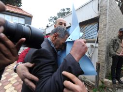 El padre de Mohamed Merah sale de su casa cubriendo su rostro para evitar ser fotografiado por los medios. AFP  /