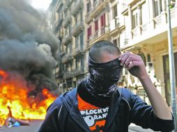 La Policía detuvo un centenar de  manifestantes por quemar contenedores y destrozar aparadores en el Centro de la ciudad.AP  /