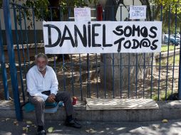 Un hombre se sienta junto a una barda que dice Todos somos Daniel en referencia a Zamudio. AFP  /