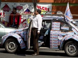 Un simpatizante de Josefina Vázquez Mota acude con su carro tapizado de 'calcas' a donde la candidata realizaba un acto de campaña. AP  /