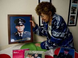 La madre de uno de los rehenes se sienta frente a la fotografía de su hijo. AFP  /