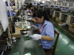 Un empleado trabaja en las placas de circuitos en una fábrica de componentes electrónicos en Hefei, provincia de Anhui. ARCHIVO  /