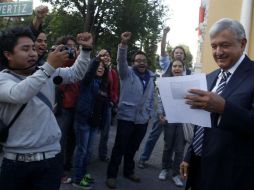López Obrador, al salir de la conferencia, se reunió con estudiante de la UNAM que lo esperaban para entregarle una invitación. NOTIMEX  /