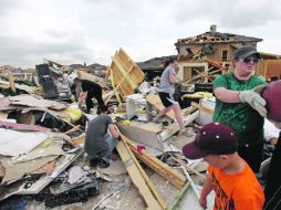 Bobbie Deen (derecha) salva las pertenencias de su madre, cuya casa, al igual que decenas más, quedó destruida. AP  /