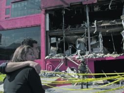 Familiares de una de las víctimas observan lo que quedó del Casino Royale tras el incendio del 25 de agosto. AFP  /