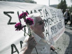 Una mujer protesta en Atenas para recordar al hombre de 77 años que se quitó la vida frente al Parlamento el miércoles pasado. AFP  /