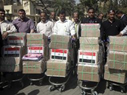 Miembros del equipo de Omar Suleiman llevan cajas con documentos con recomendaciones a la sede electoral. EFE  /