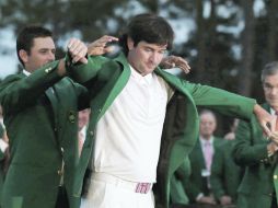 l sudafricano Charl Schwartzel, campeón del Masters 2011, cumple el ritual de colocarle el Saco Verde al nuevo campeón. REUTERS  /