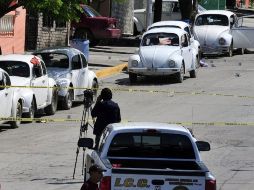 Expertos forenses y policías revisan el sitio donde un grupo armado asesinó a cinco taxistas. EFE  /