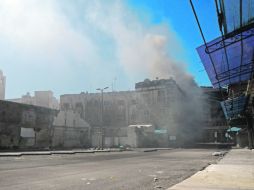 En la imagen, una nube de humo brota tras un ataque del Ejército sirio en la ciudad de Homs. AP  /
