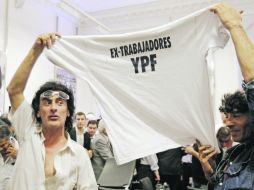 En la imagen, dos ex empleados de la petrolera Repsol YPF luego del acto presidido por la presidenta de Argentina.  /